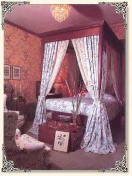 The Forest View room is furnished in splendor with a period claw foot tub between tall windows.